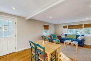 a living room with a table and a blue couch at Seabreeze Escape in Falmouth