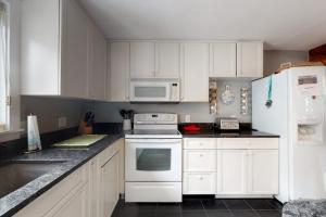 a kitchen with white cabinets and a white refrigerator at Need a Bigger Boat in Edgartown