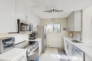 a kitchen with white cabinets and a sink at Twin Ponds in Oak Bluffs