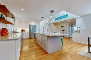 a large kitchen with white cabinets and a staircase at Cape Bliss in Yarmouth +19 photos
