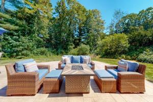 a patio with a table and wicker chairs and a table and chairs at Osterville Odyssey in Osterville
