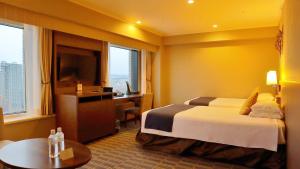 a hotel room with a bed and a desk at Premier Hotel Nakajima Park Sapporo in Sapporo