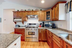 a kitchen with wooden cabinets and stainless steel appliances at Osterville Odyssey in Osterville