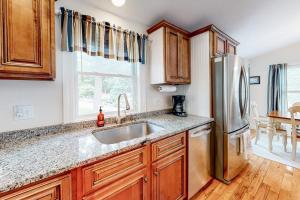 a kitchen with a sink and a refrigerator at Osterville Odyssey in Osterville +22 photos