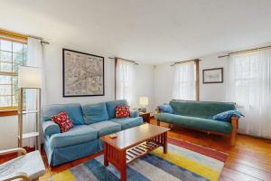 a living room with two blue couches and a coffee table at Sheep Pond Bow House in Brewster