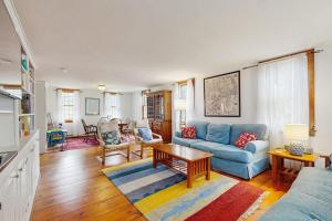 a living room with a blue couch and a table at Sheep Pond Bow House in Brewster