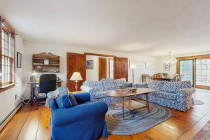 a living room with blue couches and a table at Sheep Pond Bow House in Brewster +27 photos