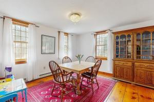 a dining room with a wooden table and chairs at Sheep Pond Bow House in Brewster