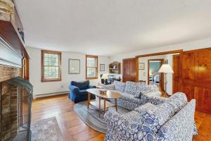 a living room with blue furniture and a fireplace at Sheep Pond Bow House in Brewster