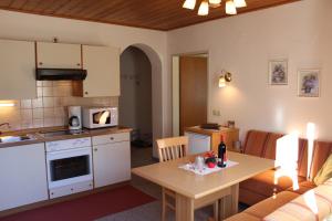 a kitchen and living room with a table and a couch at Appartements Eggenhofer in Sankt Jakob in Defereggen