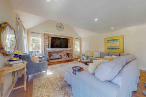 a living room with a blue couch and a fireplace at Plum Paradise in Barnstable