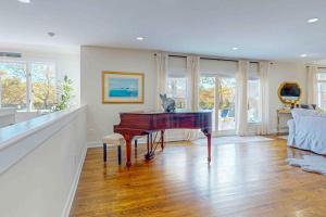 a living room with a piano and a couch at Plum Paradise in Barnstable
