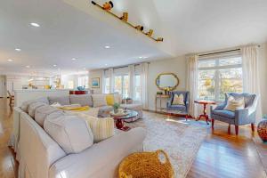 a living room with a large white couch and chairs at Plum Paradise in Barnstable