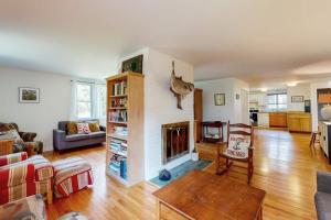 a living room with a fireplace and a couch at Oak Leaf Cape Cottage in Oak Bluffs