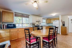 a kitchen with a wooden table and chairs in it at Oak Leaf Cape Cottage in Oak Bluffs