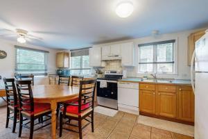 a large kitchen with a wooden table and chairs at Oak Leaf Cape Cottage in Oak Bluffs +13 photos