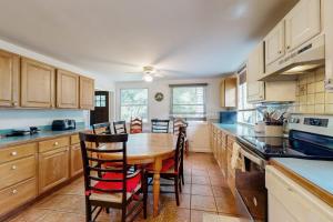 a kitchen with a wooden table and chairs in it at Oak Leaf Cape Cottage in Oak Bluffs