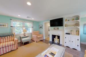 a living room with a fireplace and a flat screen tv at Cape River Retreat in Centerville