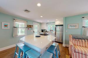 a kitchen with a large island with blue chairs at Cape River Retreat in Centerville