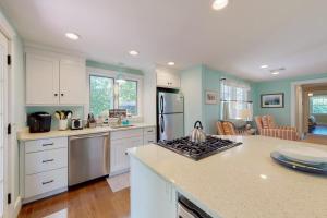 a kitchen with white cabinets and a stove top oven at Cape River Retreat in Centerville