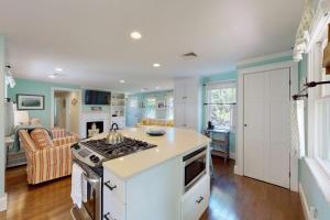 a kitchen with a stove top oven next to a living room at Cape River Retreat in Centerville +18 photos