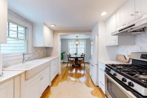 a kitchen with white cabinets and a table in it at Island Home in Vineyard Haven