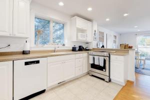 a kitchen with white cabinets and a stove top oven at Modern Beach & Town Getaway in Falmouth +20 photos
