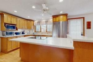 a kitchen with wooden cabinets and a white counter top at Sandbar Hideaway in Falmouth