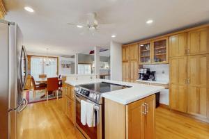 a kitchen with wooden cabinets and a stove top oven at Sandbar Hideaway in Falmouth +29 photos