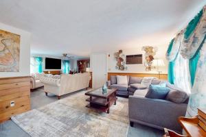 a living room with two couches and a table at Coastal Charm on the Cape in Centerville