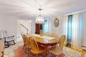 a dining room with a wooden table and chairs at Coastal Charm on the Cape in Centerville +17 photos