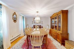 a dining room with a wooden table and chairs at Coastal Charm on the Cape in Centerville