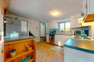 a kitchen with white cabinets and a blue counter top at Salty Ridge Station in Orleans +25 photos