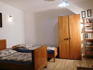 a bedroom with two beds and a book shelf at Agroturystyka pod Czarną Sosną in Biały Ług