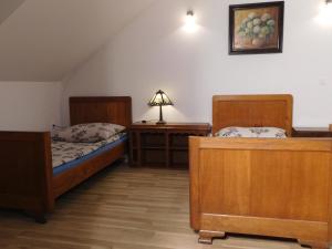 a bedroom with two beds and a table with a lamp at Agroturystyka pod Czarną Sosną in Biały Ług