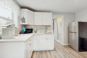 a kitchen with white cabinets and a stainless steel refrigerator at Garage Suite in Oak Bluffs