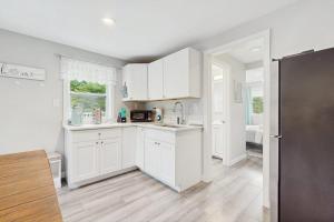 a kitchen with white cabinets and a refrigerator at Garage Suite in Oak Bluffs