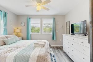 a bedroom with a bed with a ceiling fan and a tv at Garage Suite in Oak Bluffs +5 photos