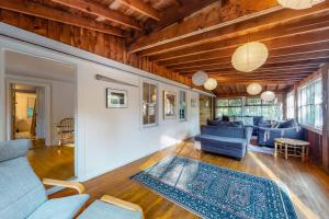 a living room with blue couches and a rug at Beachroad Hideout in Lobsterville