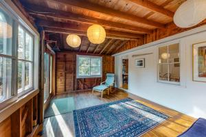 a living room with a blue chair and a rug at Beachroad Hideout in Lobsterville