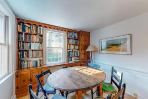 a dining room with a table and chairs and bookshelves at Beachroad Hideout in Lobsterville