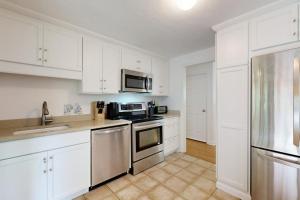 a kitchen with white cabinets and stainless steel appliances at Seabreeze in Dennis Port