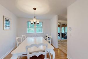 a white dining room with a white table and chairs at Seabreeze in Dennis Port