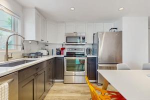 a kitchen with white cabinets and stainless steel appliances at The Grey Lady in Provincetown