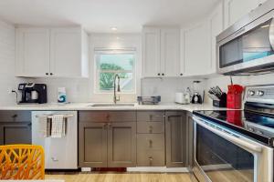 a kitchen with white cabinets and a sink at The Grey Lady in Provincetown +9 photos