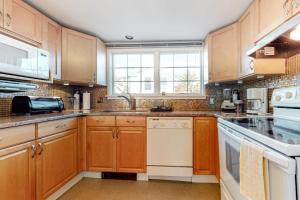 a kitchen with wooden cabinets and white appliances at Cape Point Escape in Provincetown
