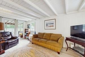 a living room with a couch and a flat screen tv at Gingerbread Dream in Oak Bluffs