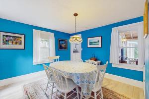 a dining room with blue walls and a table and chairs at Gingerbread Dream in Oak Bluffs