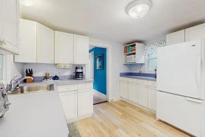 a kitchen with white cabinets and a white refrigerator at Gingerbread Dream in Oak Bluffs +14 photos