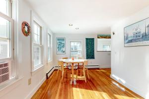 a dining room with a table and some windows at Cape Point Escape in Provincetown